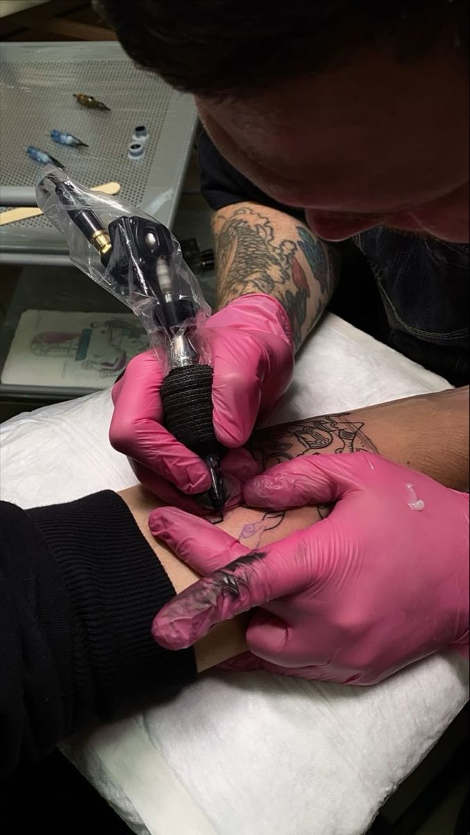 Tatuador aplicando tatuagem